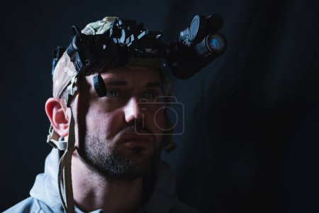 Soldat mit Nachtsichtgerät und Wärmegerät auf dem Kopf. Weichzeichner-Foto. 