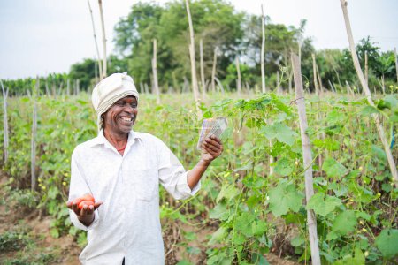 Foto de Agricultor indio sosteniendo tomate en las manos, agricultor feliz - Imagen libre de derechos