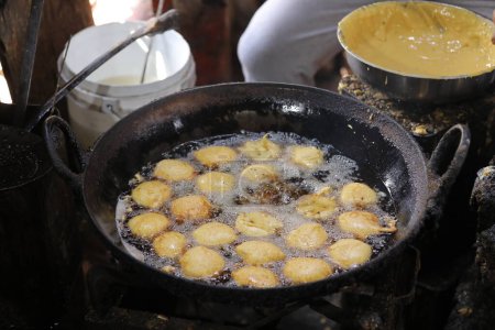 Téléchargez les photos : Friture kachori dans une poêle à frire dans un étal de nourriture de rue, nourriture grasse - en image libre de droit