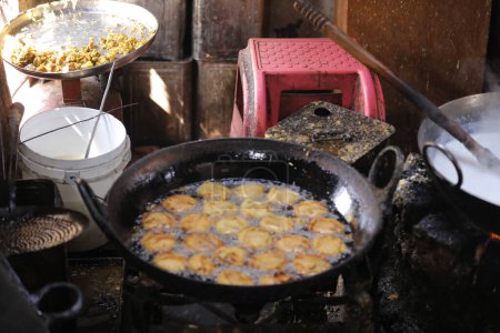 Foto de Freír kachori en una sartén en un puesto de comida callejera, comida aceitosa - Imagen libre de derechos