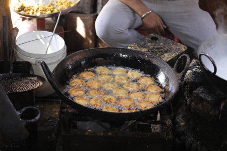 Foto de Freír kachori en una sartén en un puesto de comida callejera, comida aceitosa - Imagen libre de derechos