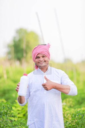 Foto de Granjero indio joven mostrando teléfono inteligente, granjero hablando por teléfono en la granja, granjero indio feliz - Imagen libre de derechos