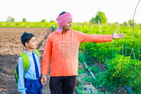 Foto de Lindo niño agricultor indio en uniforme escolar con su padre en el campo de la agricultura, feliz padre e hijo - Imagen libre de derechos
