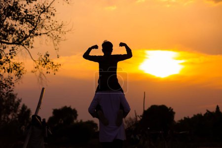 Foto de Padre cargando hijo en hombros en el campo contra el cielo, mostrando el poder de la agricultura - Imagen libre de derechos