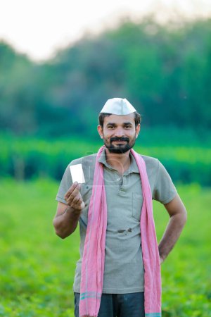 Foto de Agricultor indio con tarjeta de cajero automático en las manos, agricultor indio feliz, árbol de guisantes - Imagen libre de derechos