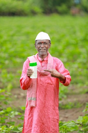 Foto de India feliz granjero sosteniendo vacío botella en las manos, feliz granjero mostrando blanco botella - Imagen libre de derechos