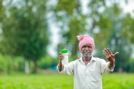 Foto de India feliz granjero sosteniendo vacío botella en las manos, feliz granjero mostrando blanco botella - Imagen libre de derechos