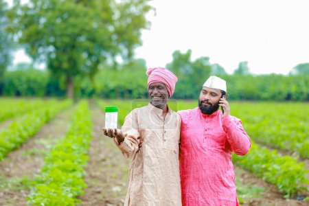 Foto de La agricultura india. dos granjeros sosteniendo botella vacía en las manos, granjero y agrónomo - Imagen libre de derechos