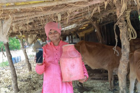 Foto de Feliz agricultor indio que vende leche en la granja - concepto de producción de leche agraria, India rural, crecimiento y agricultura - Imagen libre de derechos