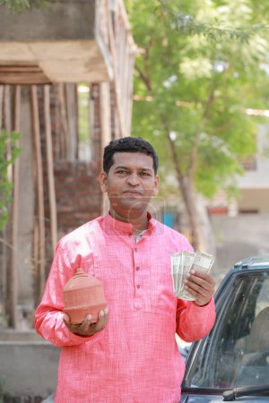 Téléchargez les photos : Agriculteur indien tenant roupie dans les mains - en image libre de droit