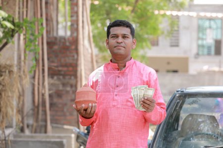 Photo for Indian farmer holding rupee in hands - Royalty Free Image
