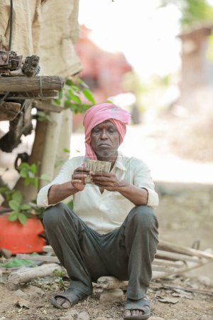 Téléchargez les photos : Rural Farmer Man Standing Field Affichage de billets en monnaie indienne - en image libre de droit