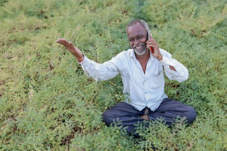 Garbanzos indios Agricultura, granja india feliz sosteniendo el teléfono móvil en las manos, pobre granjero feliz