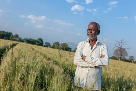 Indischer Bauer steht auf Weizenfeld, Glücklicher Bauer
