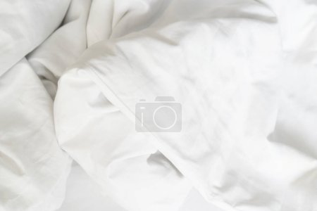 Téléchargez les photos : Vue de dessus du pli d'un drap de lit non confectionné dans la chambre après une longue nuit de sommeil et de réveil le matin
. - en image libre de droit