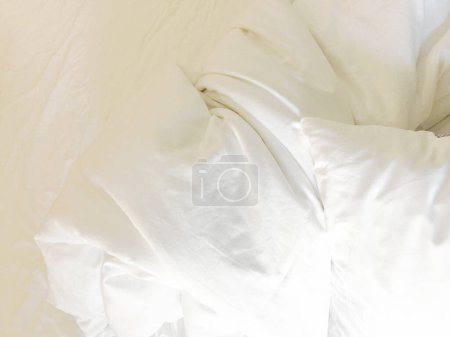 Téléchargez les photos : Lit non confectionné ; taies d'oreiller ridées, drap de lit et couette. - en image libre de droit