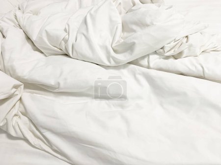 Ungeschminktes Bett; faltige Kissenbezüge, Bettlaken und Bettdecken.