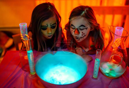 Téléchargez les photos : Halloween fête des enfants et des potions avec du liquide lumineux et de la fumée - en image libre de droit