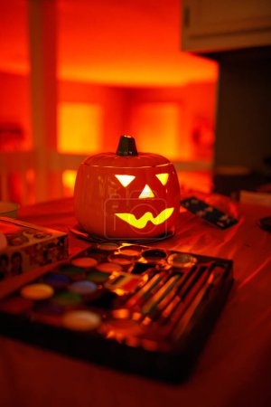 Photo for Illuminated Jack-o'-Lantern and Halloween Face Paint Setup - Royalty Free Image