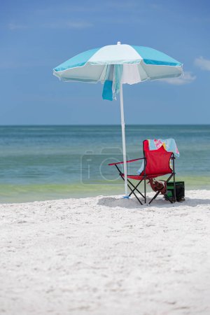 Foto de Sombrilla de la silla de playa en arena con más fresco y toalla en el océano con fondo de cielo - Imagen libre de derechos