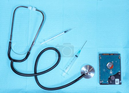 Foto de Bandeja médica con estetoscopio, agujas y unidad de disco que simboliza la tecnología médica y los datos - Imagen libre de derechos
