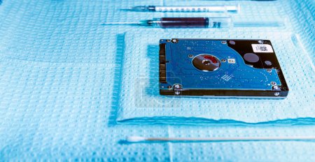 Photo for Medical tray with needles, cotton swab, and hard drive symbolizing medical technology and data - Royalty Free Image