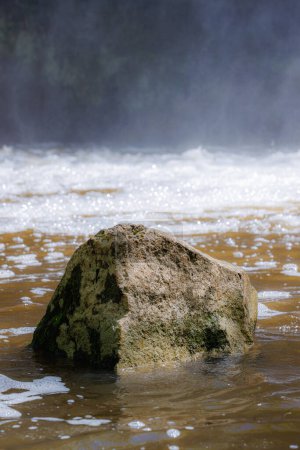 Téléchargez les photos : Roche isolée dans l'eau de rivière avec brume d'eau - en image libre de droit