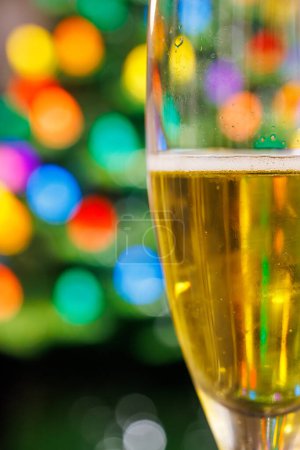 Festlicher Champagner-Glas-Toast mit buntem Weihnachts-Bokeh Ligh