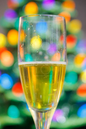 Festive Champagne Glass Toast with Colorful Christmas Bokeh Ligh
