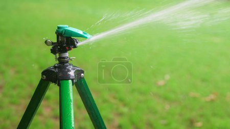 Garden Impact Pulse Sprinkler Watering Grass Lawn with Green Background
