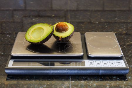Avocadohälften auf Küchenskala für Portionskontrolle und gesunde Essgewohnheiten