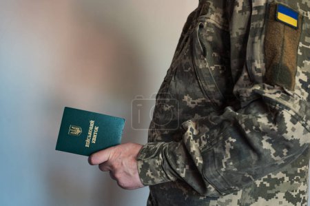 Soldat Veteran im Kampfanzug hält Militärausweis in der Hand. Ukrainische Pixeluniform