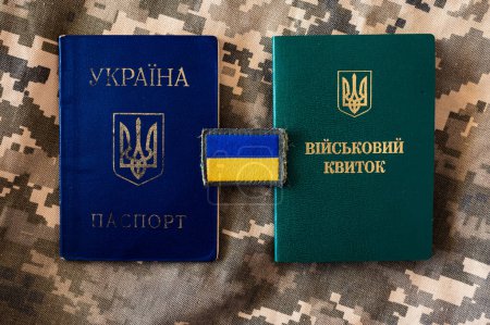 Ukrainischer Pass und Militärausweis mit Flagge der Ukraine. Hintergrund der Pixel-Tarnung
