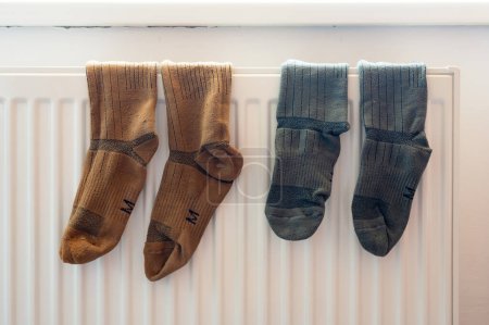 Photo for Two pairs of tactic military socks on the white radiator after washing. Housing, economy, domestic theme - Royalty Free Image