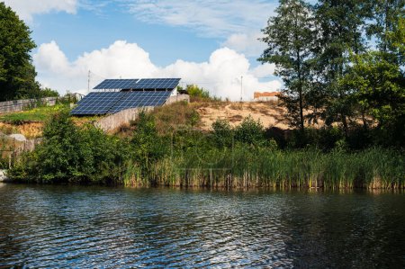 Photo for Solar power station with solar panels on bank of river. Clean solar energy, ecological, eco theme - Royalty Free Image