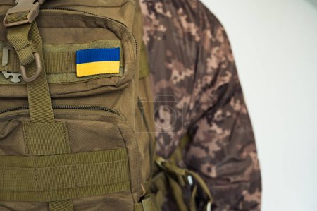 Ukrainian soldier combat in pixel military uniform with tactic backpack coyote color and flag of Ukraine