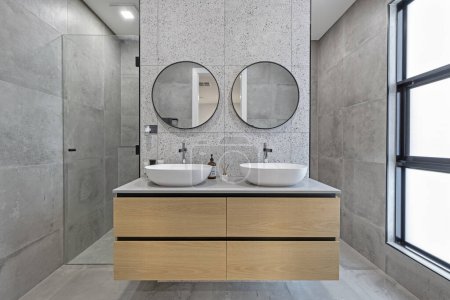 Téléchargez les photos : Salle de bain moderne avec douche, vanité en bois, lavabo duo et miroirs doubles - en image libre de droit