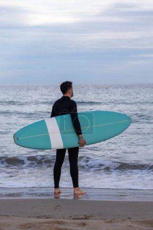 Foto de Surfista con neopreno y tabla de surf en la playa - Imagen libre de derechos