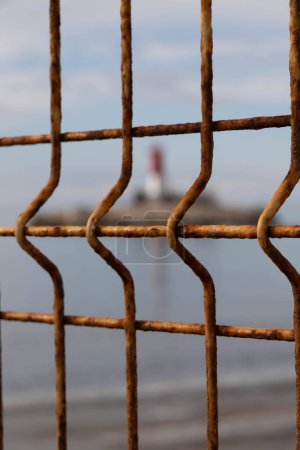 Lighthouse in the sea with a fence