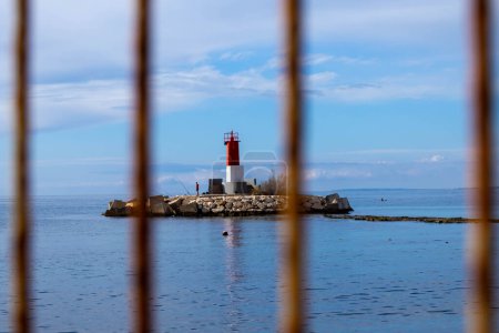 Lighthouse in the sea with a fence