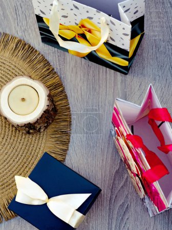 three color paper present bags and wooden candle on green background