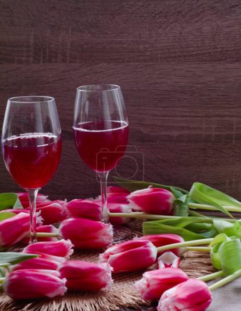 Photo for Bouquet of beautiful spring flowers, laying red tulips, two glasses of aromatic red wine. Woman day. - Royalty Free Image