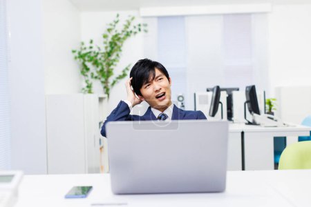 Foto de Joven empresario japonés se siente frustrado en la oficina - Imagen libre de derechos