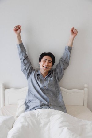 Téléchargez les photos : Portrait de beau jeune asiatique homme à la maison dans son lit - en image libre de droit
