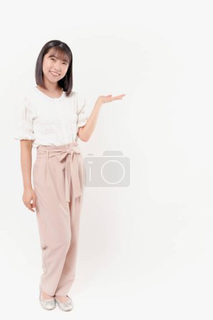 Téléchargez les photos : Femme japonaise avec pose montrant quelque chose sur fond blanc - en image libre de droit