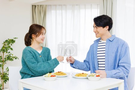Foto de Feliz asiático pareja tostadas en la cocina - Imagen libre de derechos
