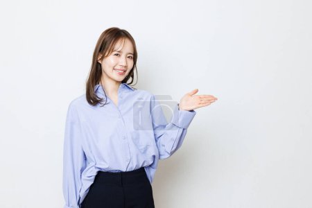 Photo for Portrait of asian woman in blue shirt showing something on hand - Royalty Free Image
