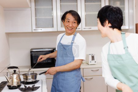 Photo for Middle aged asian man and woman cooking together - Royalty Free Image