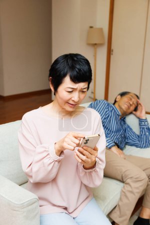 Photo for Senior asian woman calling emergency her husband is sick - Royalty Free Image