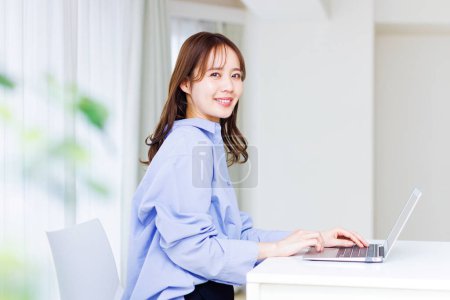 Young Japanese woman working at home. Remote working concept
